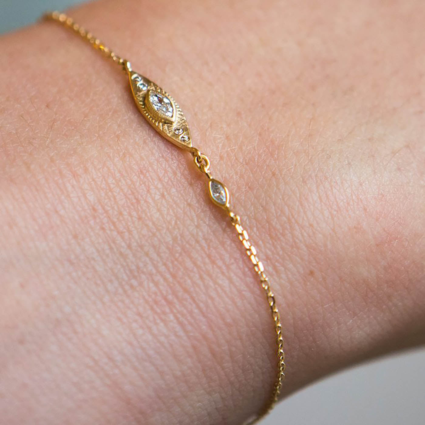 Sun Eye Diamond Bracelet in 14K yellow gold featuring a central diamond eye design and smaller diamond accents, displayed on a wrist, showcasing fine jewelry craftsmanship and cultural significance.