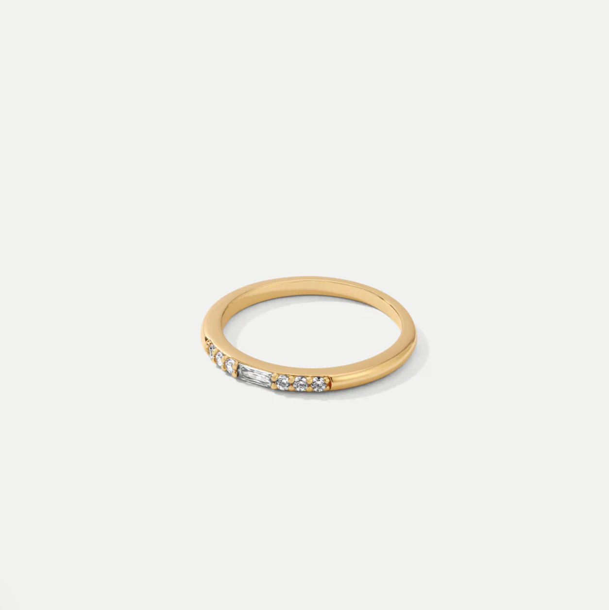 slim gold ring with embedded cz on a white background