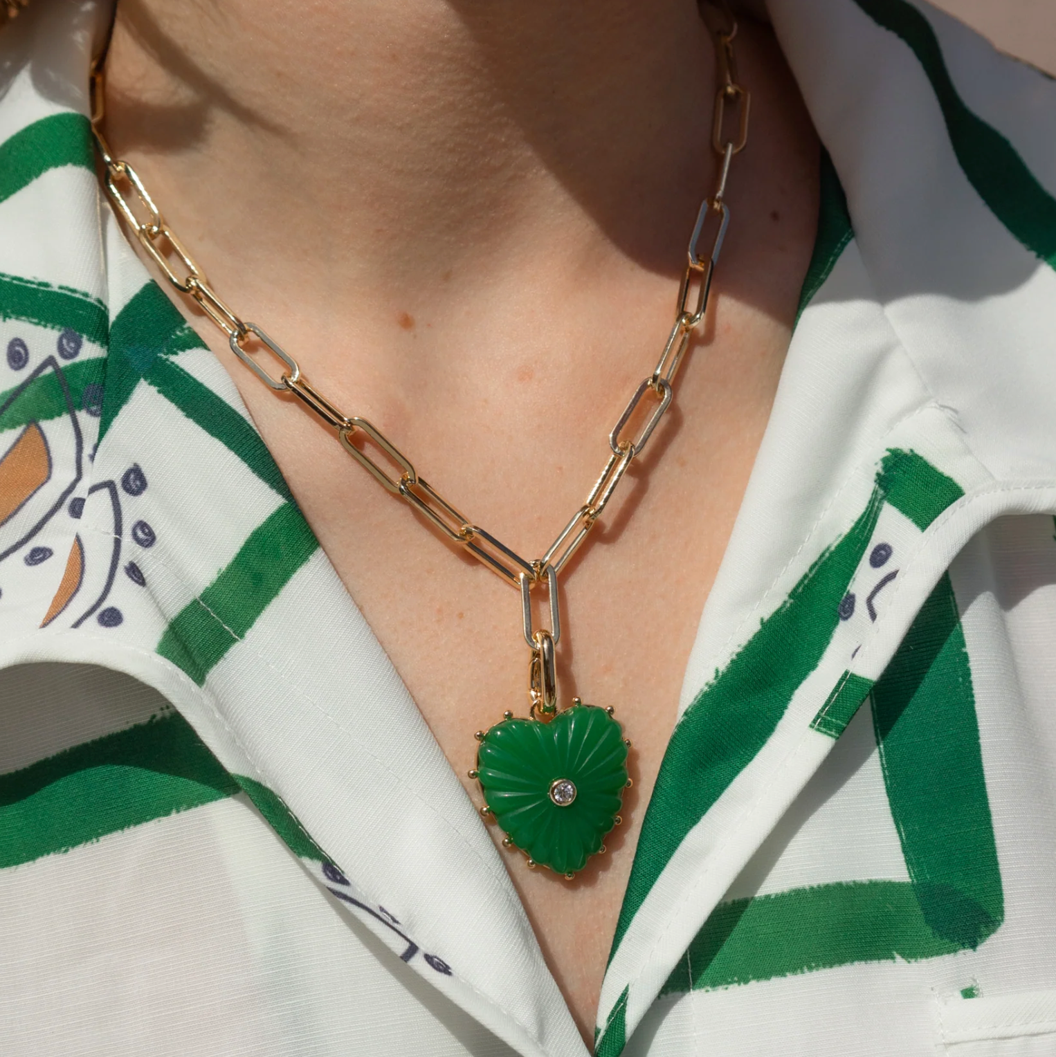 Heart-shaped green mother of pearl pendant with gold accents and cubic zirconia, featured in Brave Daughters' Malene Clip Necklace collection.