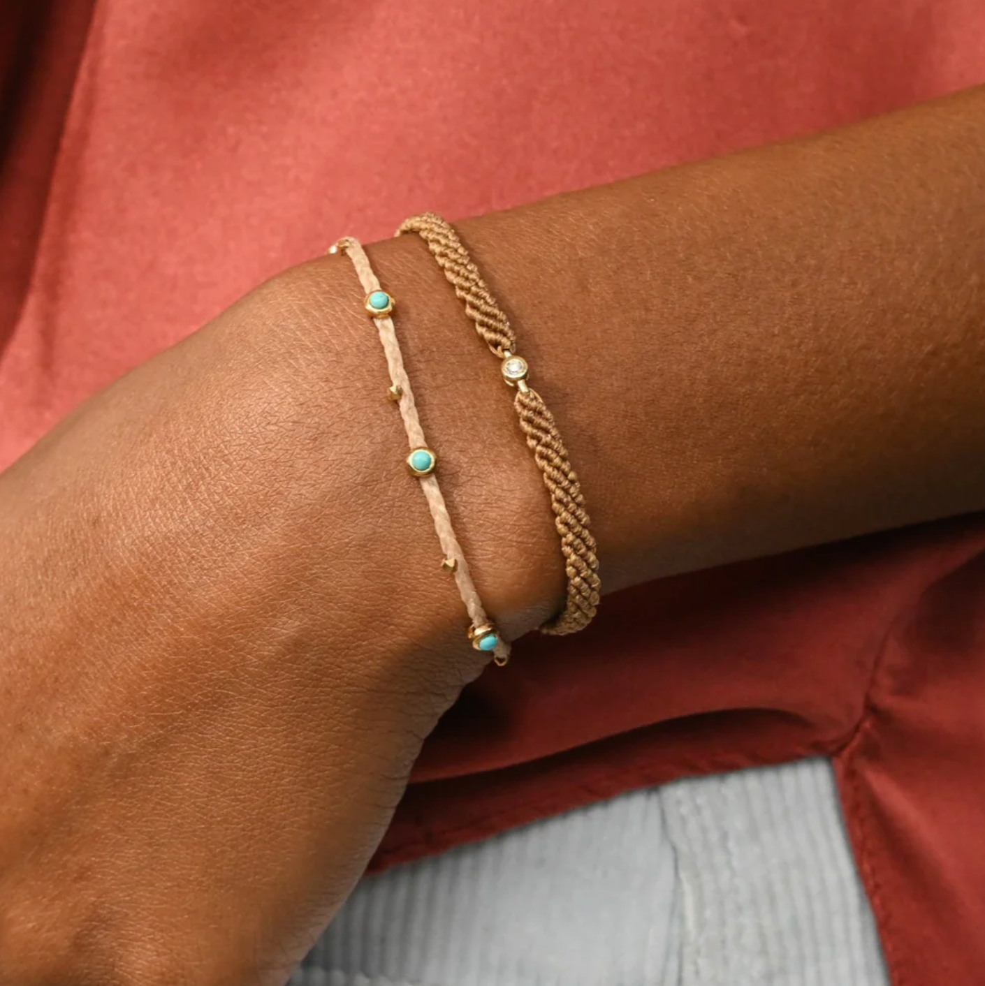 Nylon Gold bracelet with turquoise stones on a wrist against a red background