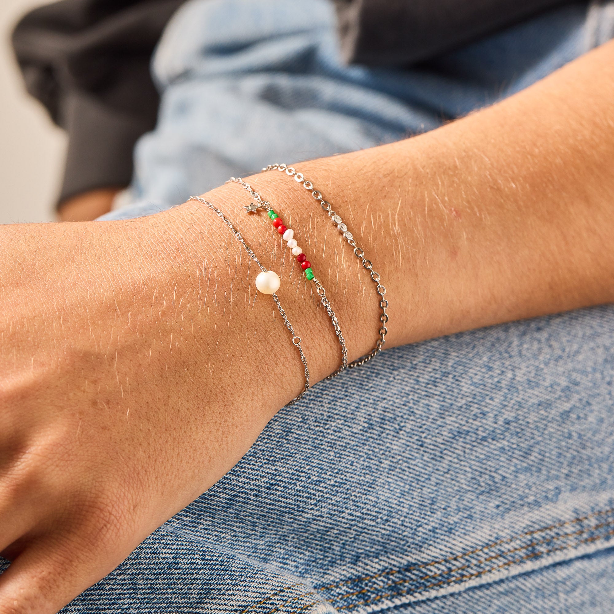 Stacked white gold and stainless steel permanent bracelets from Brave Daughters with pearl, star, and colorful beaded bar charms — welded fine jewelry for modern, minimal styling.