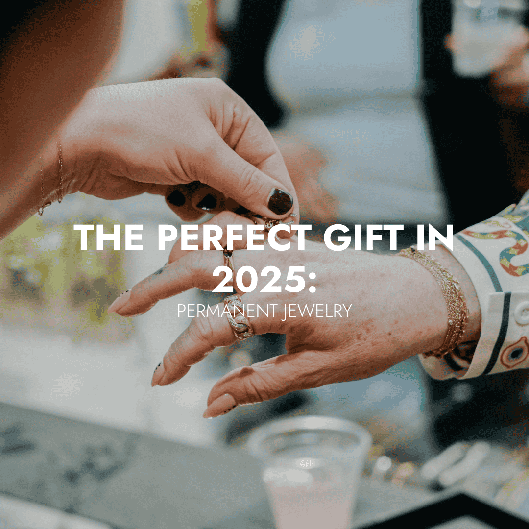 Close-up of one person helping another see a piece at a jewelry counter, with the text “The Perfect Gift in 2025: Permanent Jewelry” overlaid on the image.