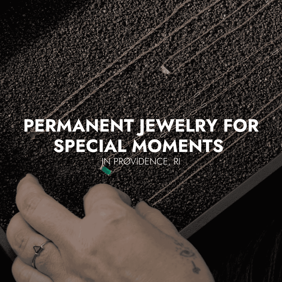 Permanent jewelry chains displayed on a tray with a hand selecting a necklace at Brave Daughters in Providence, RI for special moments.