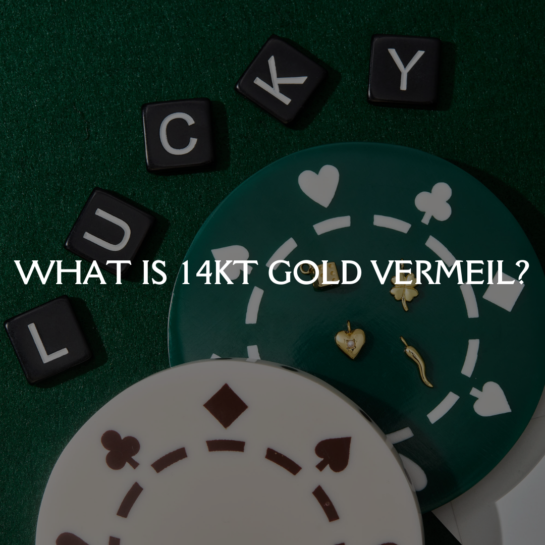 14kt gold vermeil charms displayed on playing card–inspired surface, explaining what gold vermeil jewelry is and how it’s made.