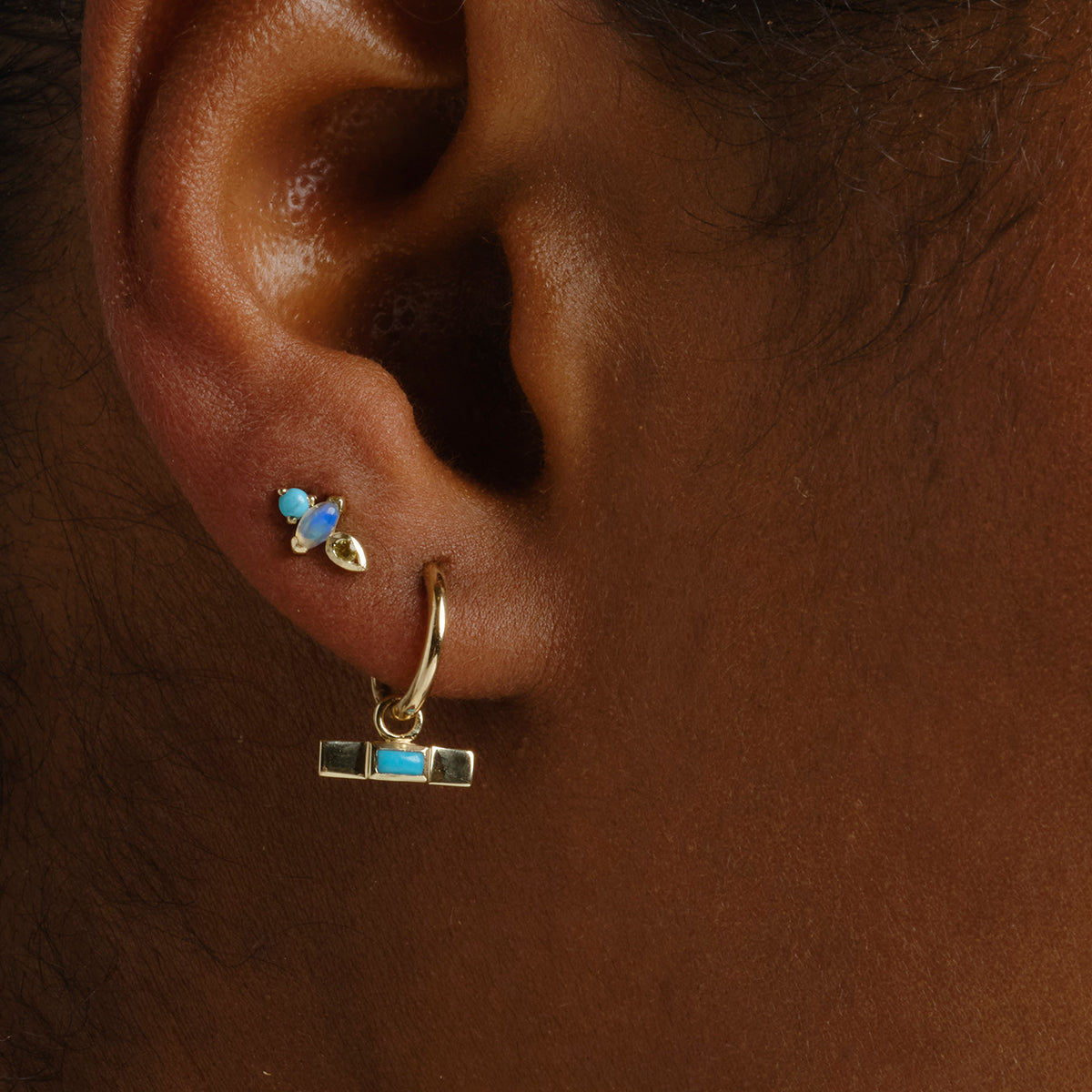 Close-up of Ear with Turquoise and Opal Stud Earrring