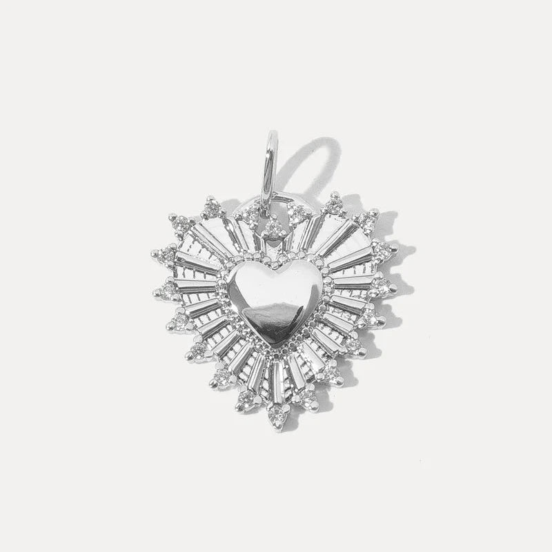 a silver heart shaped charm with delicate stone details on a white background