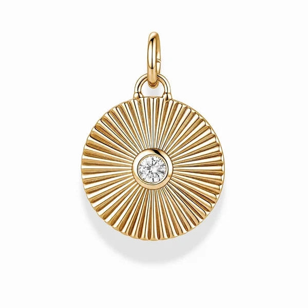 A gold sunburst pendant charm featuring a central round clear gemstone, shown on a clean white background.