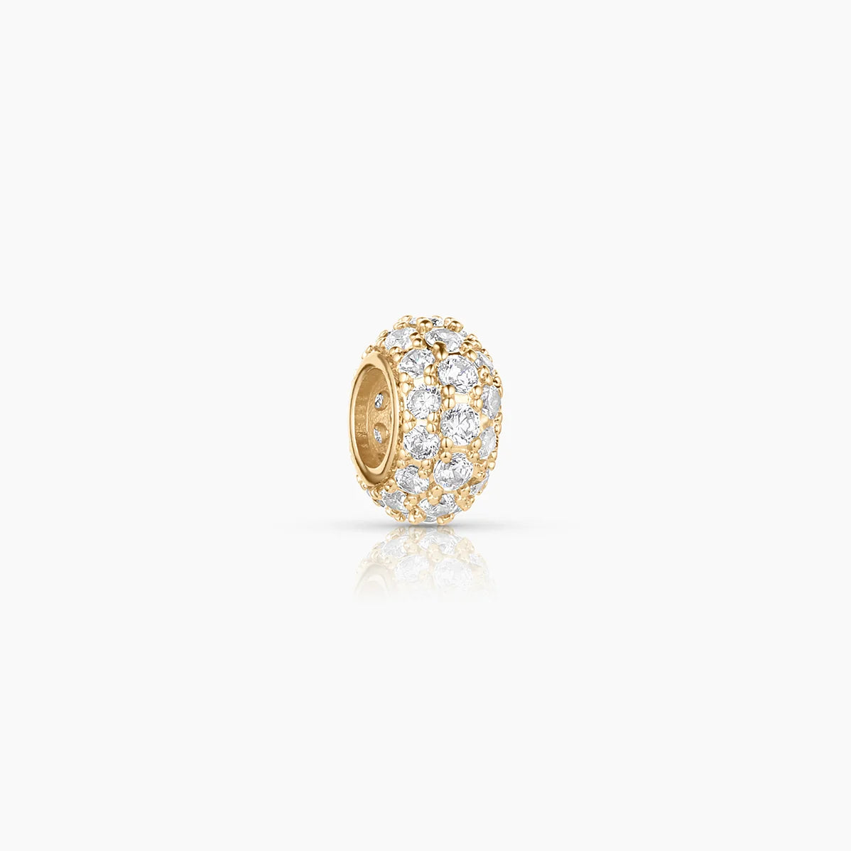 a gold bead charm with pave inlay over a white background