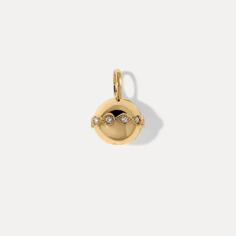 a gold orb charm with intricate detailing and gemstone accents on a white background