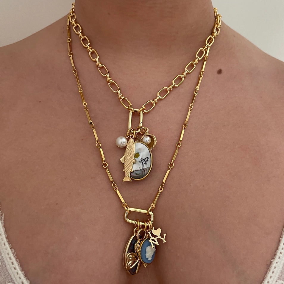 Gold chain necklace with charms on a person's neck