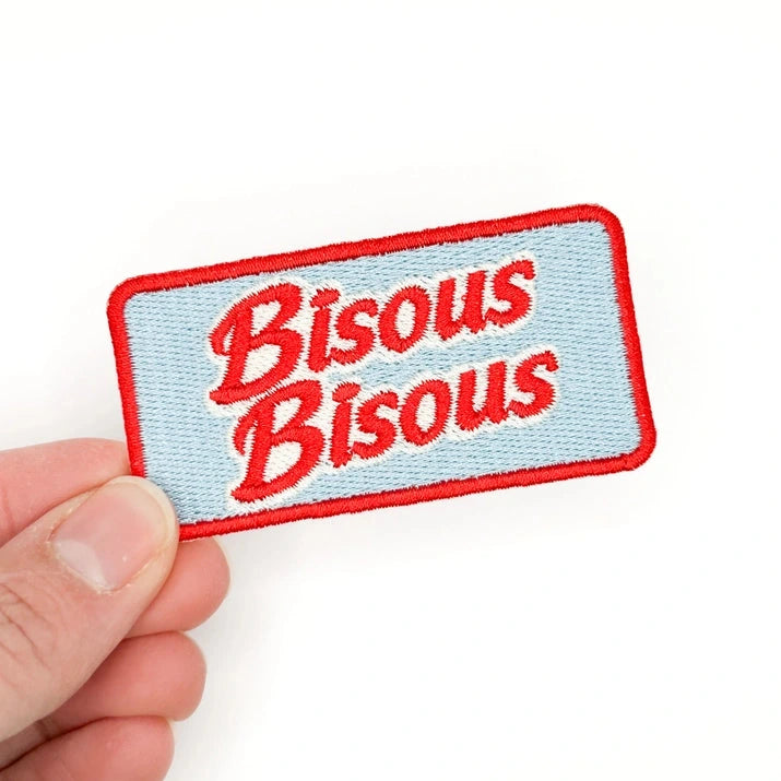 a red and blue patch with text reading bisous bisous and a white background