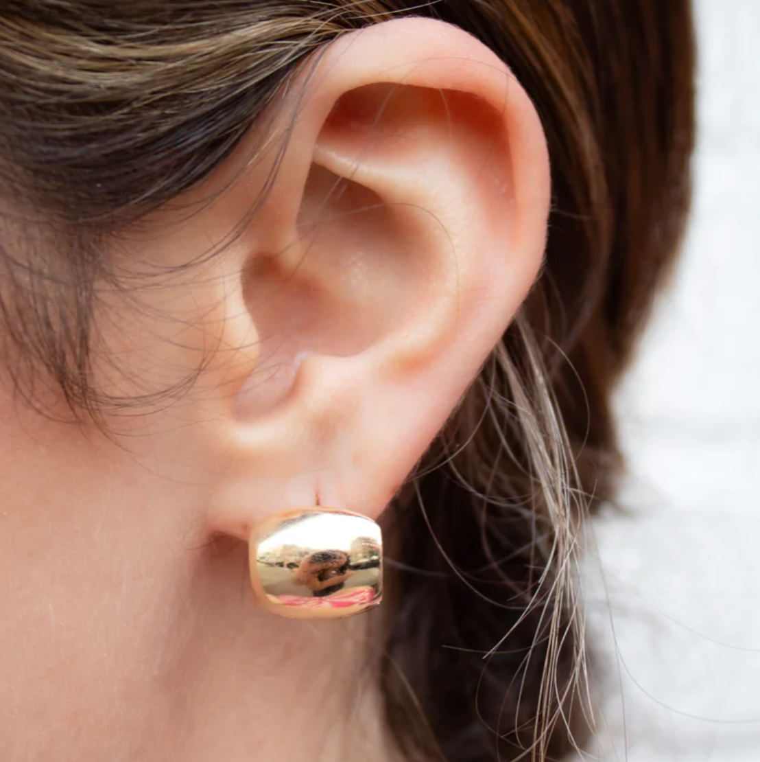 Gold Chunky Barrel Hinge Hoop earring worn by a person 