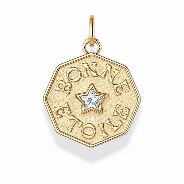 A gold-tone octagonal pendant charm featuring the engraved French text 'BONNE TOILE' surrounding a central star with a clear gemstone, shown on a clean white background.