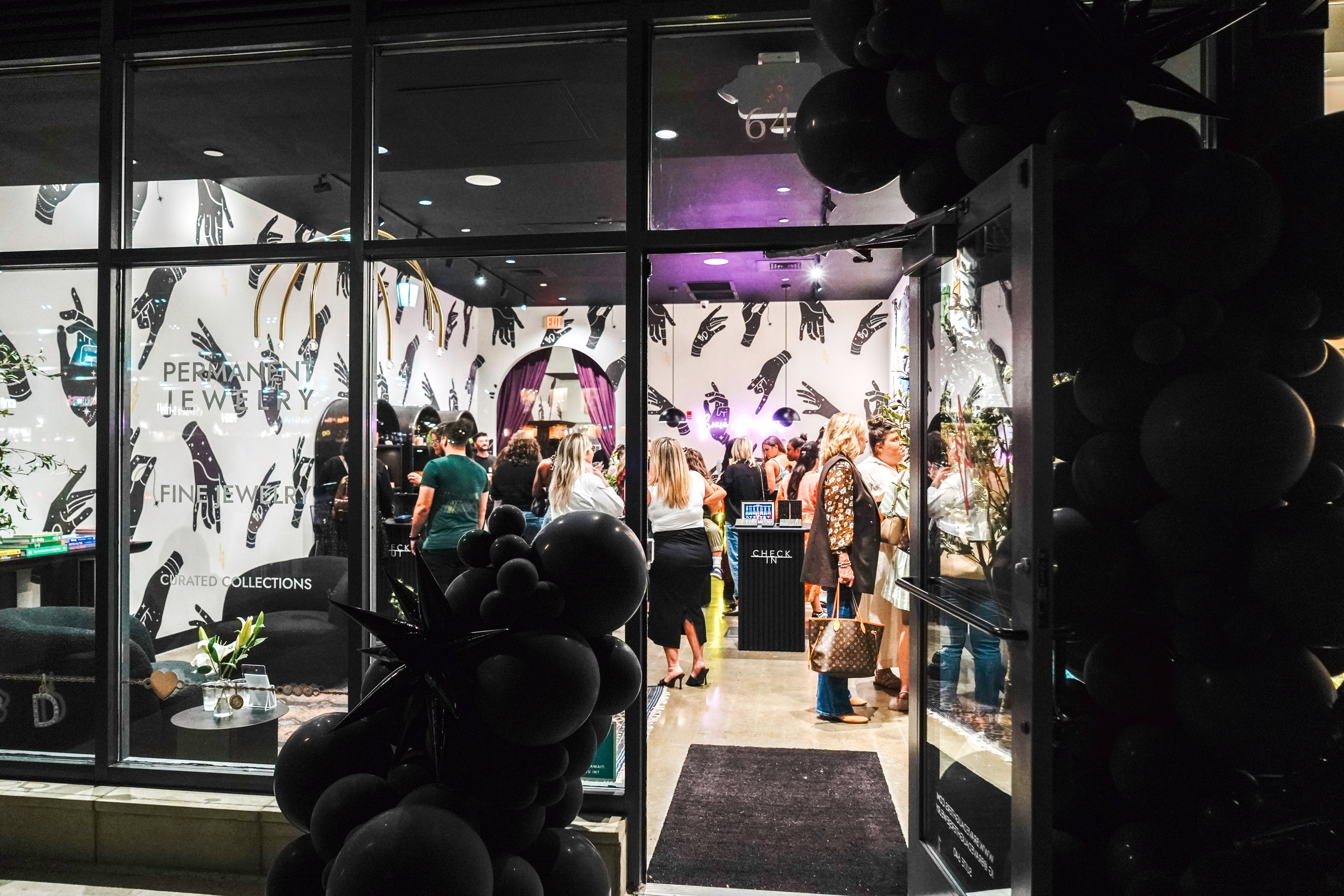 Interior of Brave Daughters Legacy Place dedham store with large glass windows displaying fashion items and people inside.