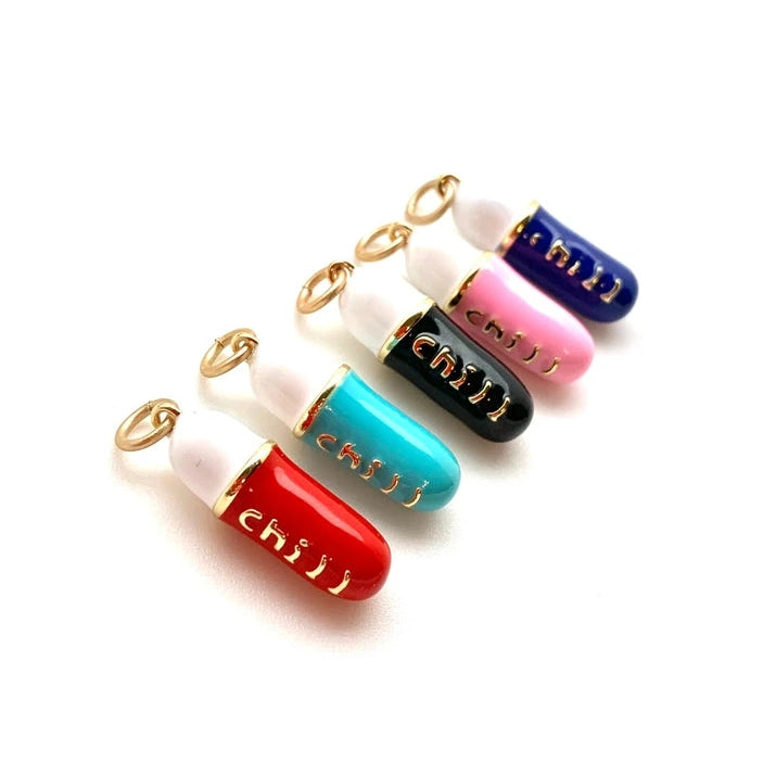 white and multi-colored pill-shaped charms with gold text reading chill on a white background