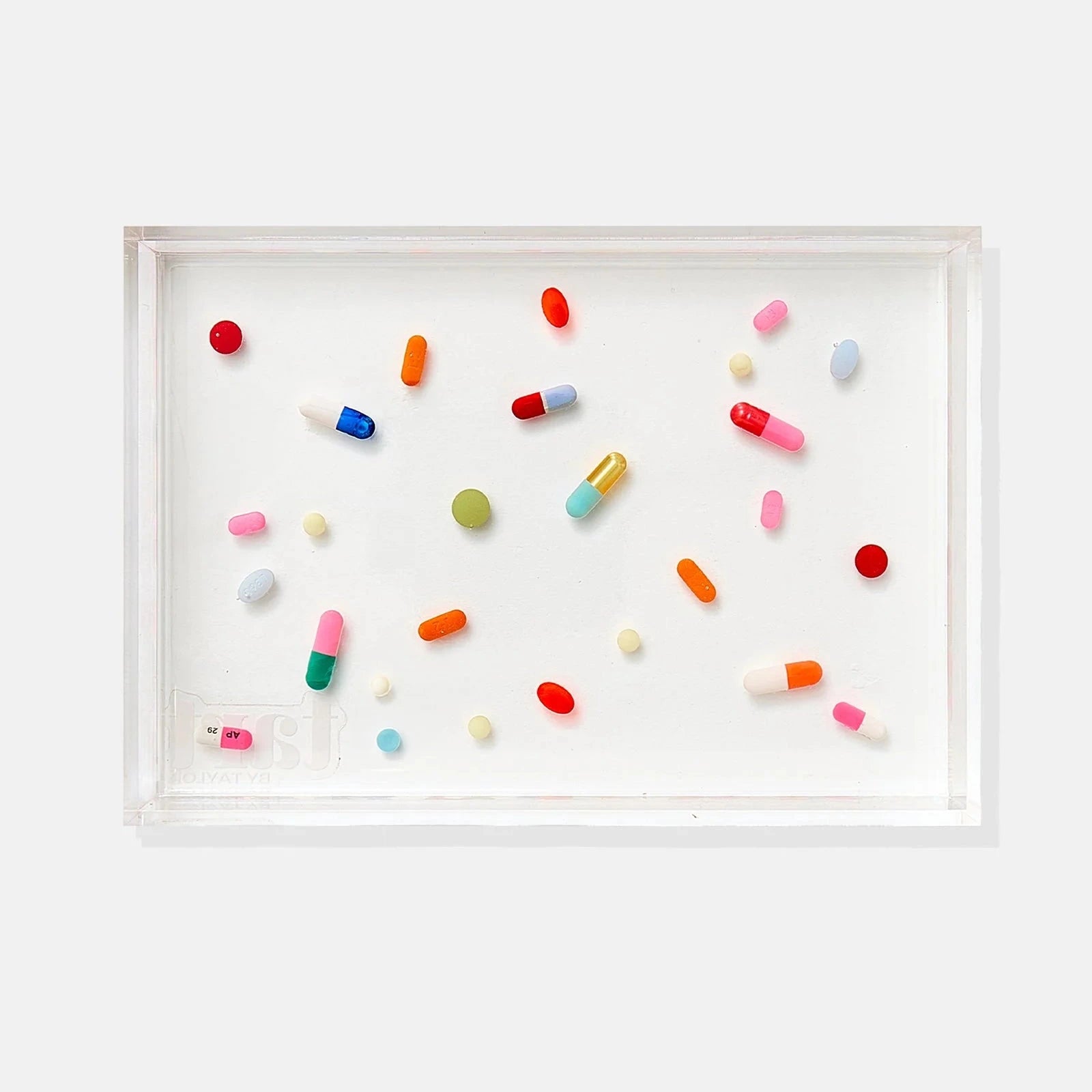 an acrylic tray with pills scattered throughout the design on a white background