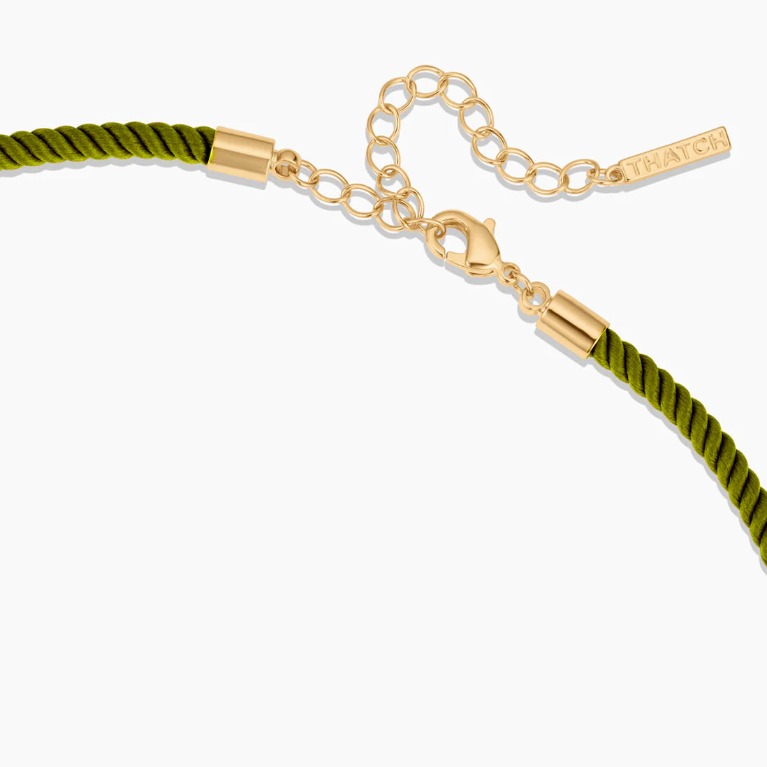 Green braided bracelet with gold clasp on a white background