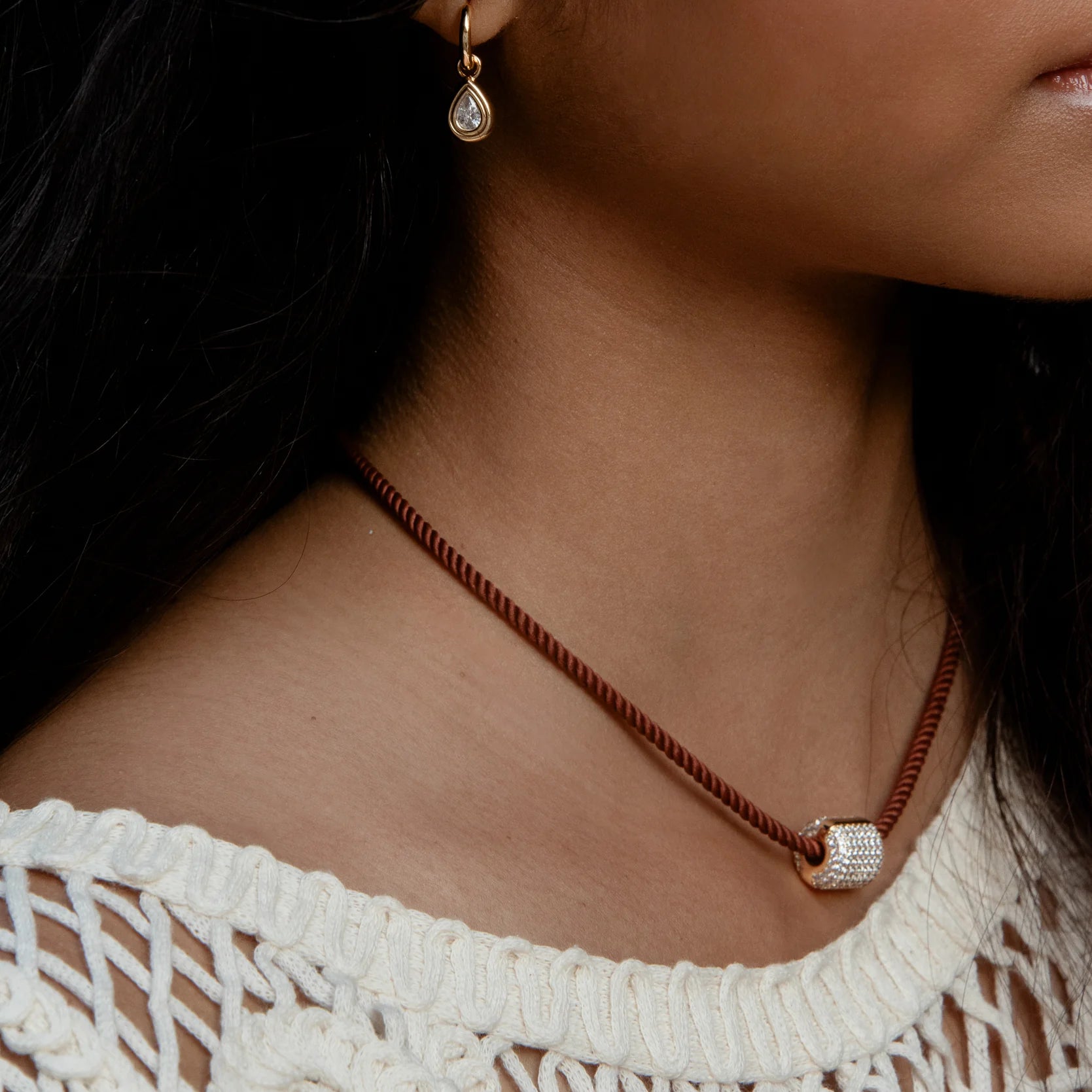 Necklace with a pendant worn by a person, close-up of the necklace.