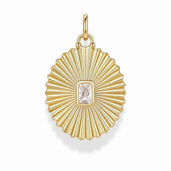 A gold pendant with a sunburst or fan-like ribbed design and a rectangular clear gemstone in the center, shown on a plain white background.