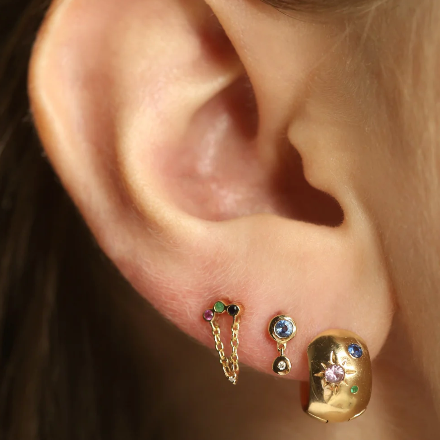 10k Gold huggie hoop with colorful gemstones on a  model