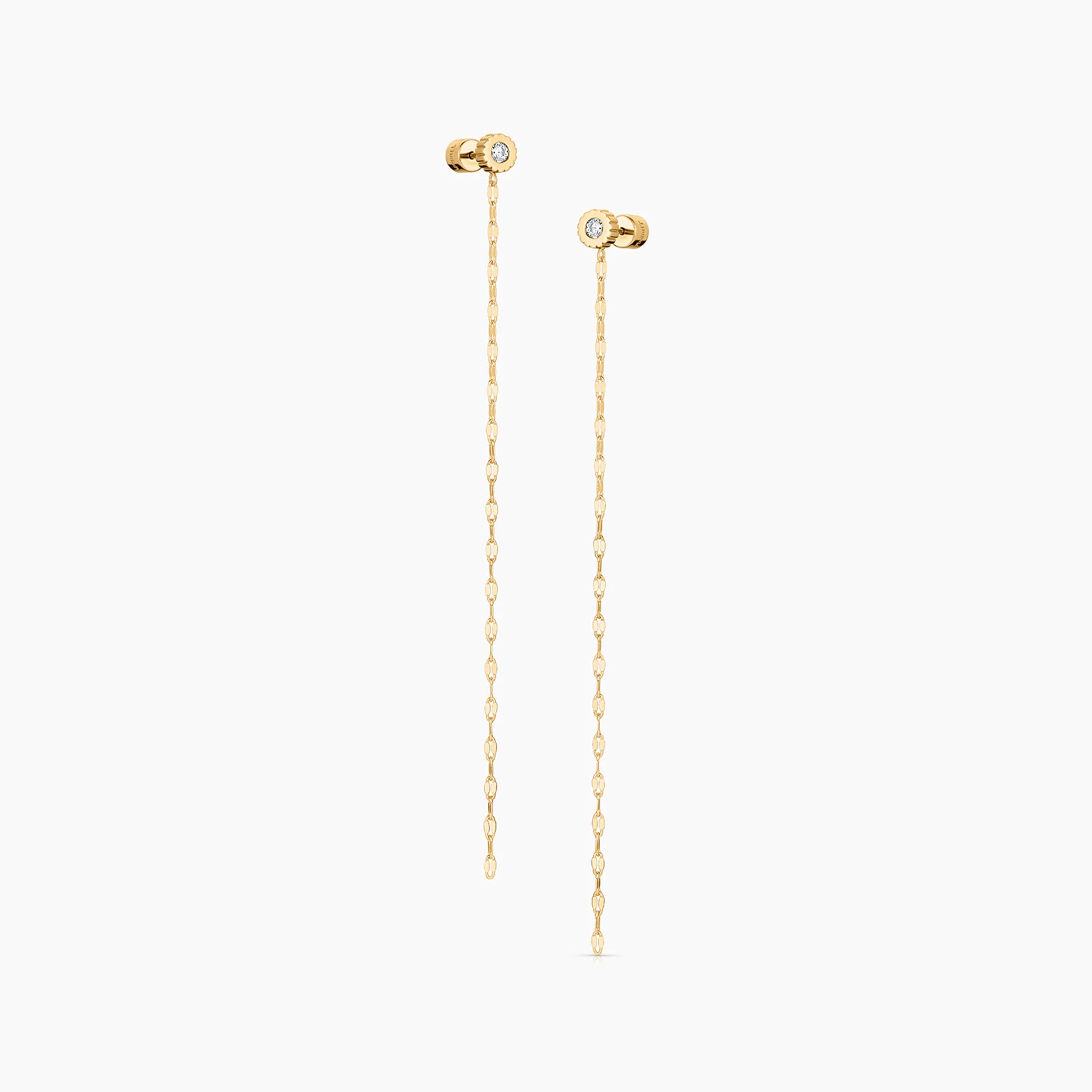 two circular stud earrings with white inlay stones and chain drops over a white background