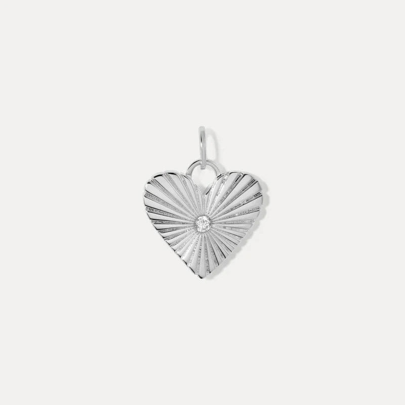 a heart shaped silver charm with a white cz in the center on a white background
