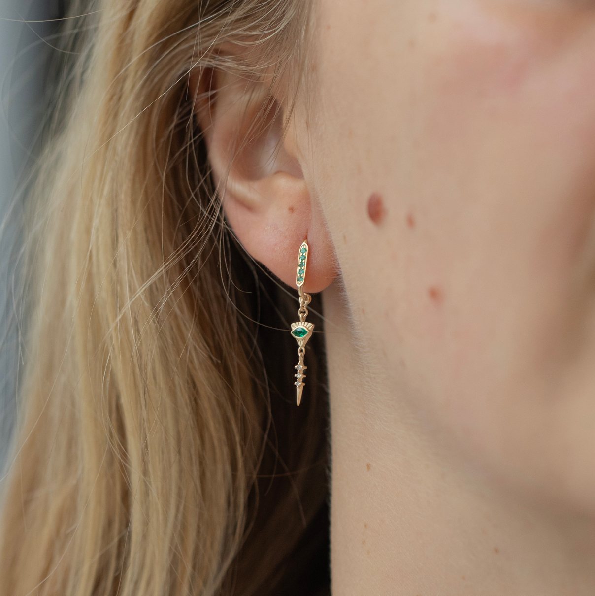 "14K solid yellow gold earrings with 0.16 ct emeralds and 0.03 ct dangling diamonds — 3 cm long with butterfly backs, sold as a pair; emeralds symbolize love, harmony, and compassion.