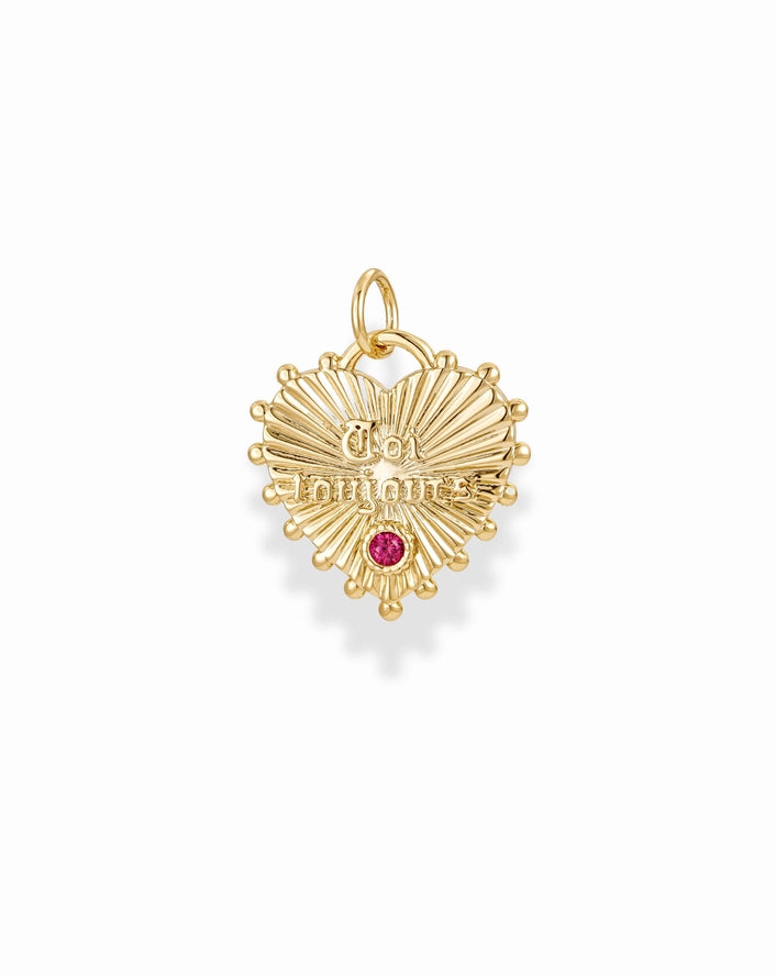 a gold heart shaped charm with a red cz accent on a white background