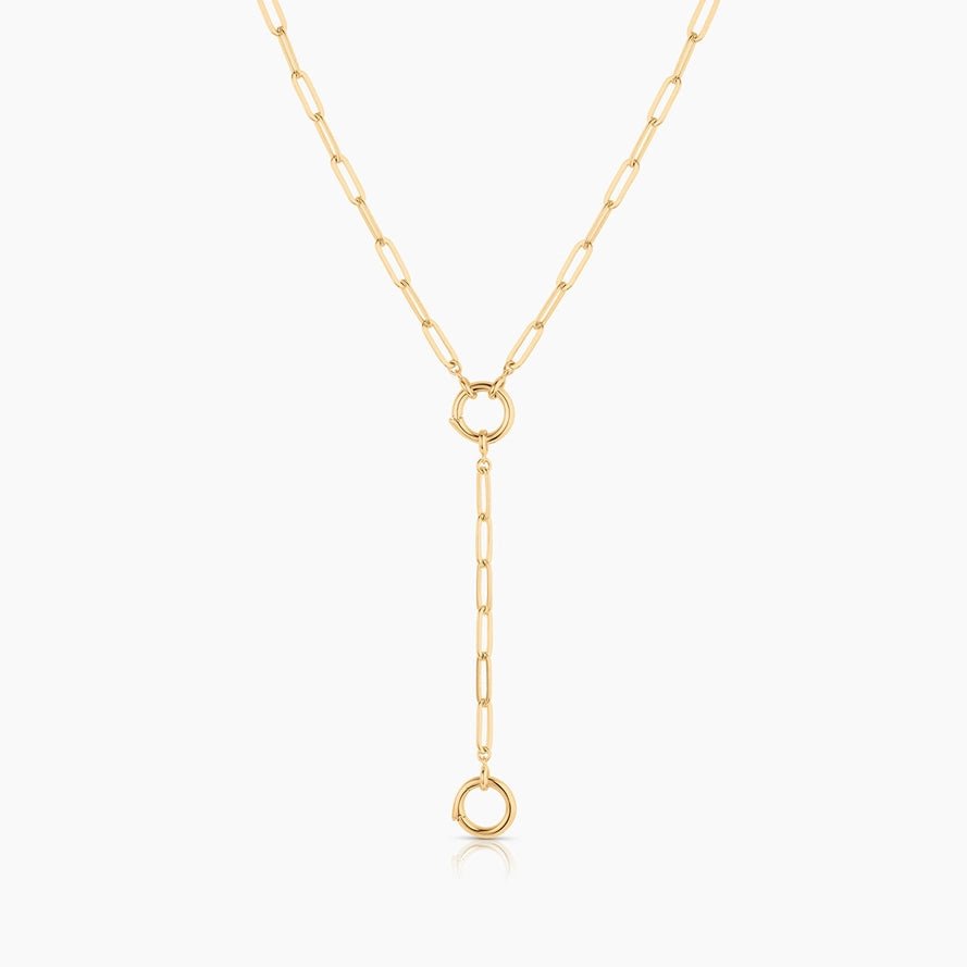 a gold paperclip chain with a ring clasp attachment attached to a ring clasp on a gold paperclip chain on a white background