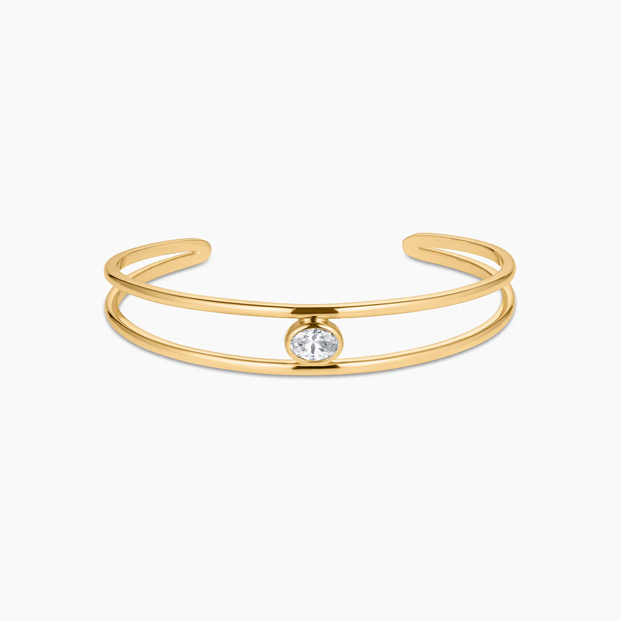 Gold bracelet with a single crystal on a white background