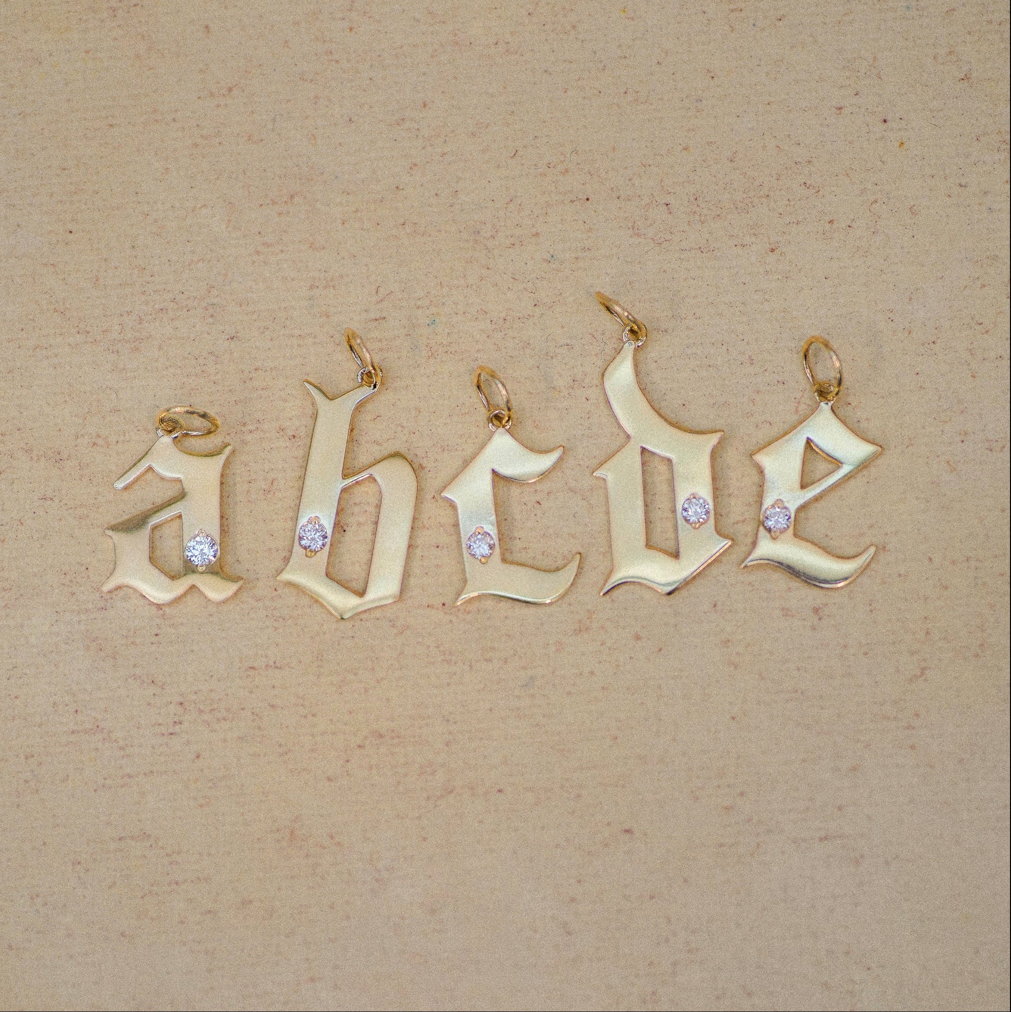 Gold letter pendants on a beige background