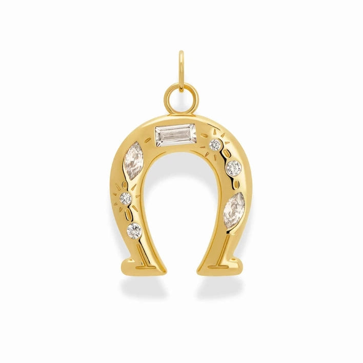a gold plated charm in the shape of a horseshoe with cubic zirconia accents of various shapes on a white background