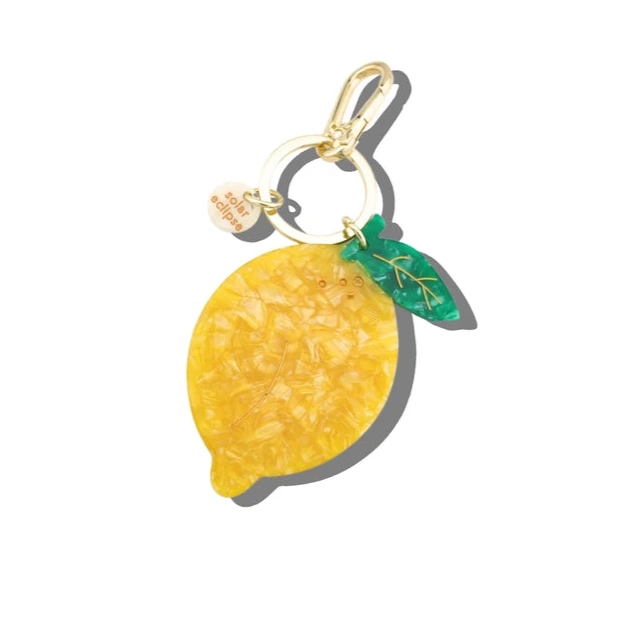 Lemon-shaped keychain with a gold tag on a white background