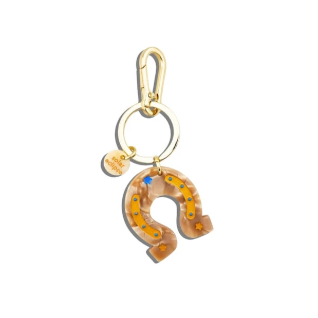 Horseshoe-shaped keychain with gold clasp on a white background