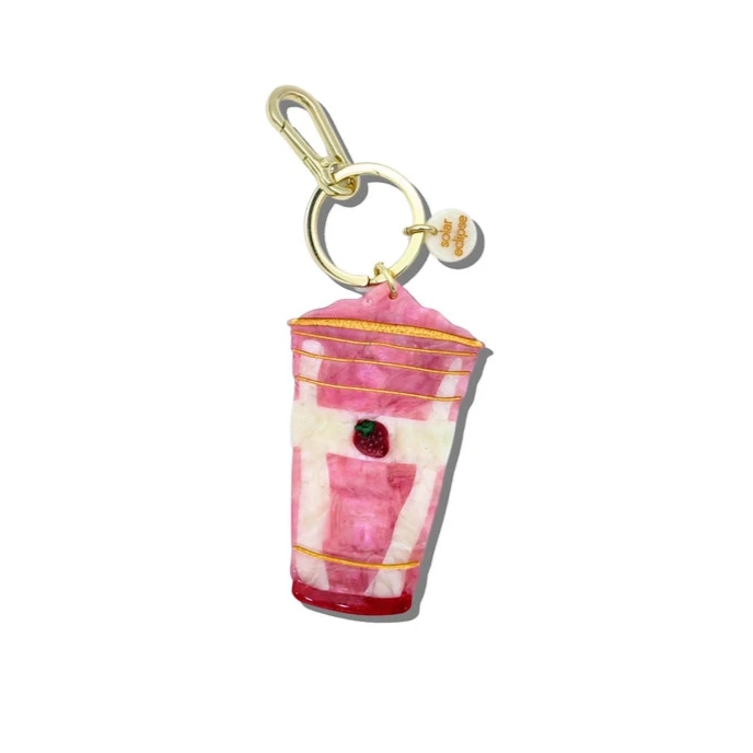 Pink cup-shaped keychain with gold accents on a white background