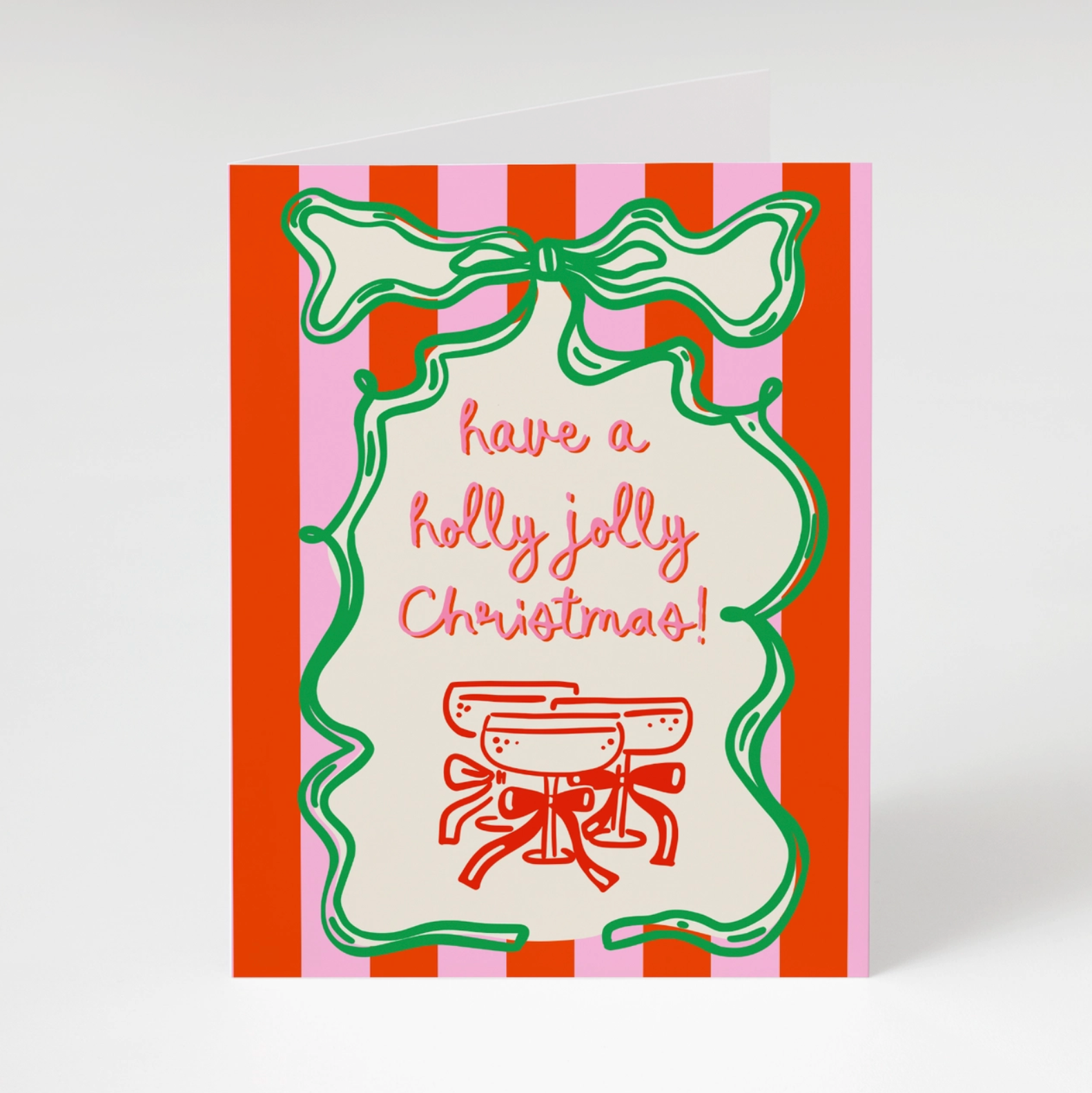 red and pink striped greeting card with the words have a holly jolly christmas and a green bow on white background