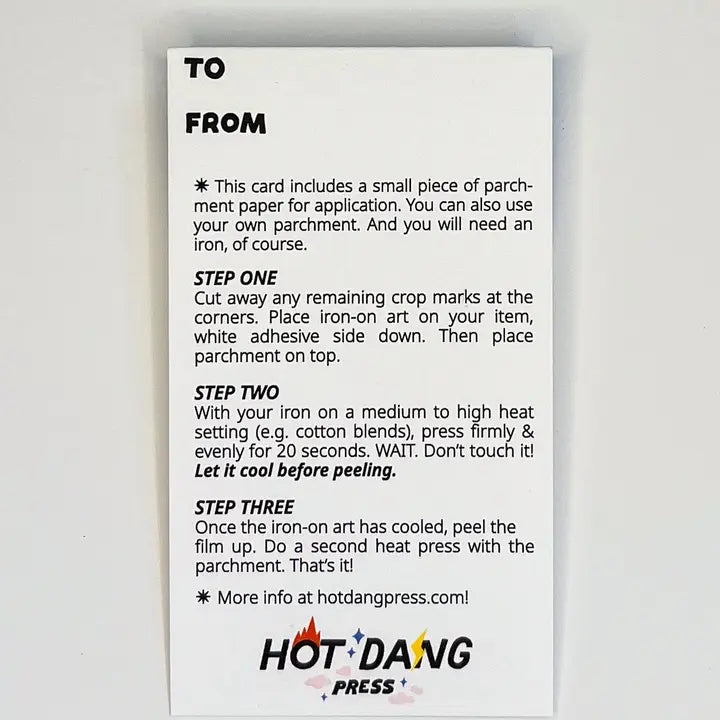 A white rectangular instruction card with black text explaining how to apply an iron-on art film, including steps one through three and a Hot Dang Press logo at the bottom, photographed against a light gray background.