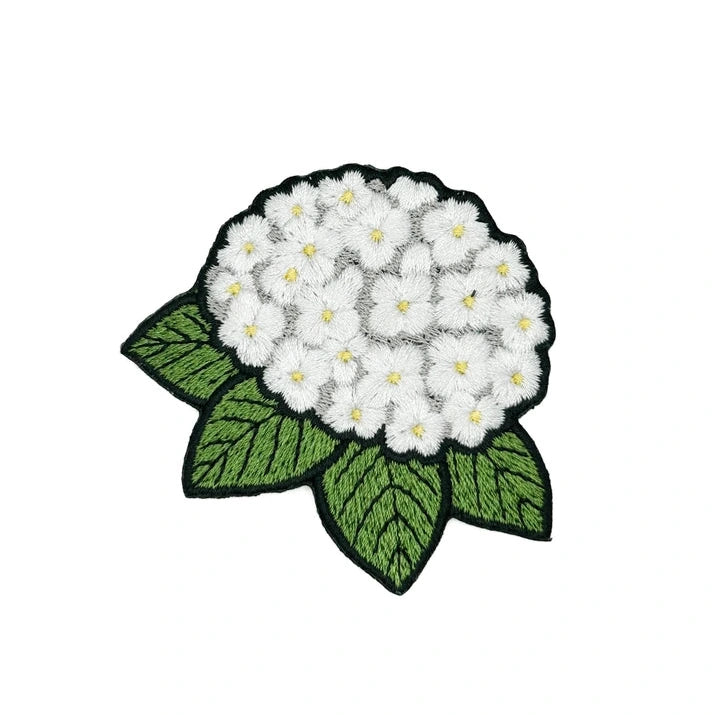 a green black and white iron on patch in the shape of a hydrangea flower on a white background
