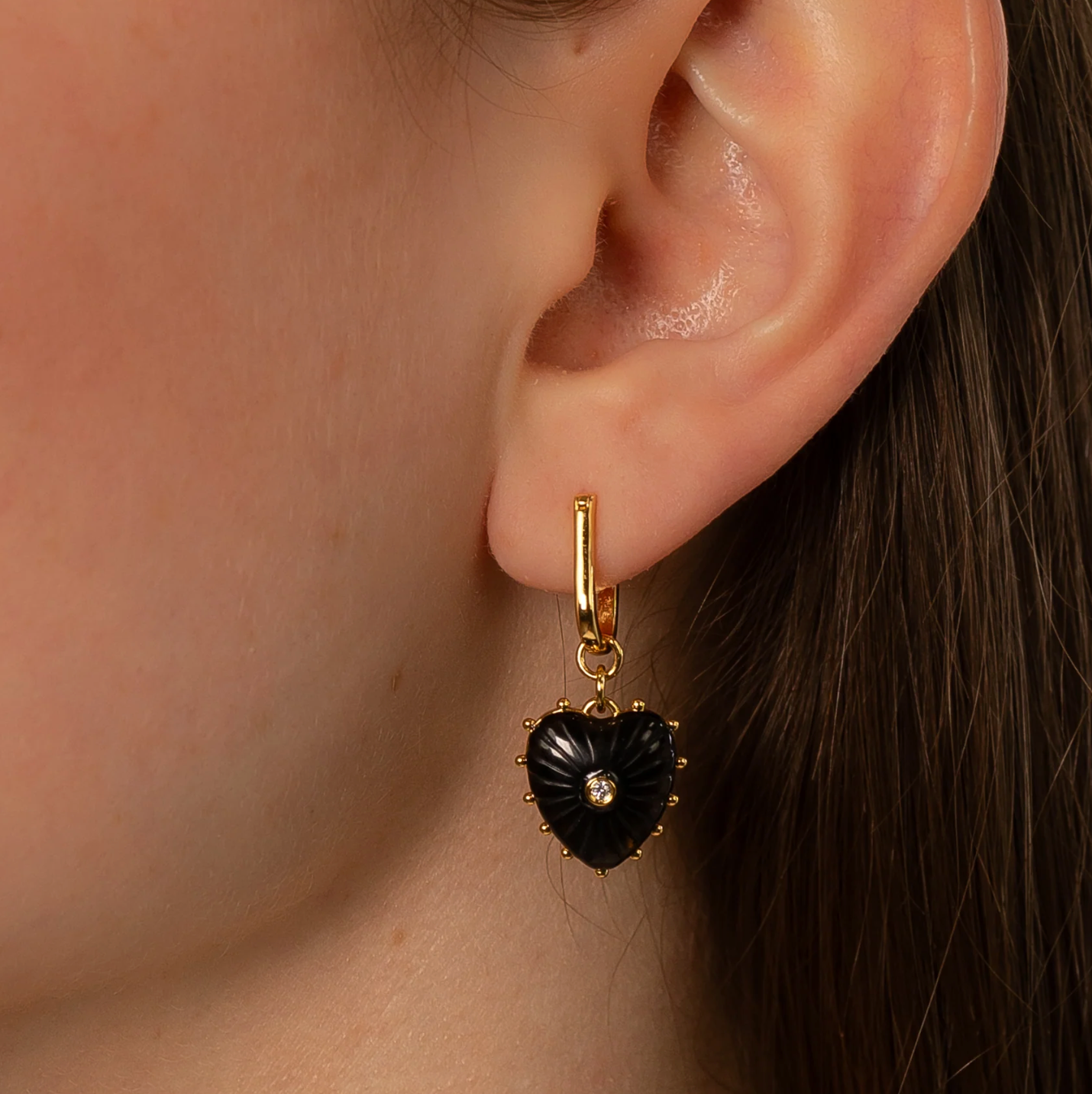 14k gold plated hoop earrings with removable hand-carved onyx heart charms and cubic zirconia center stones.