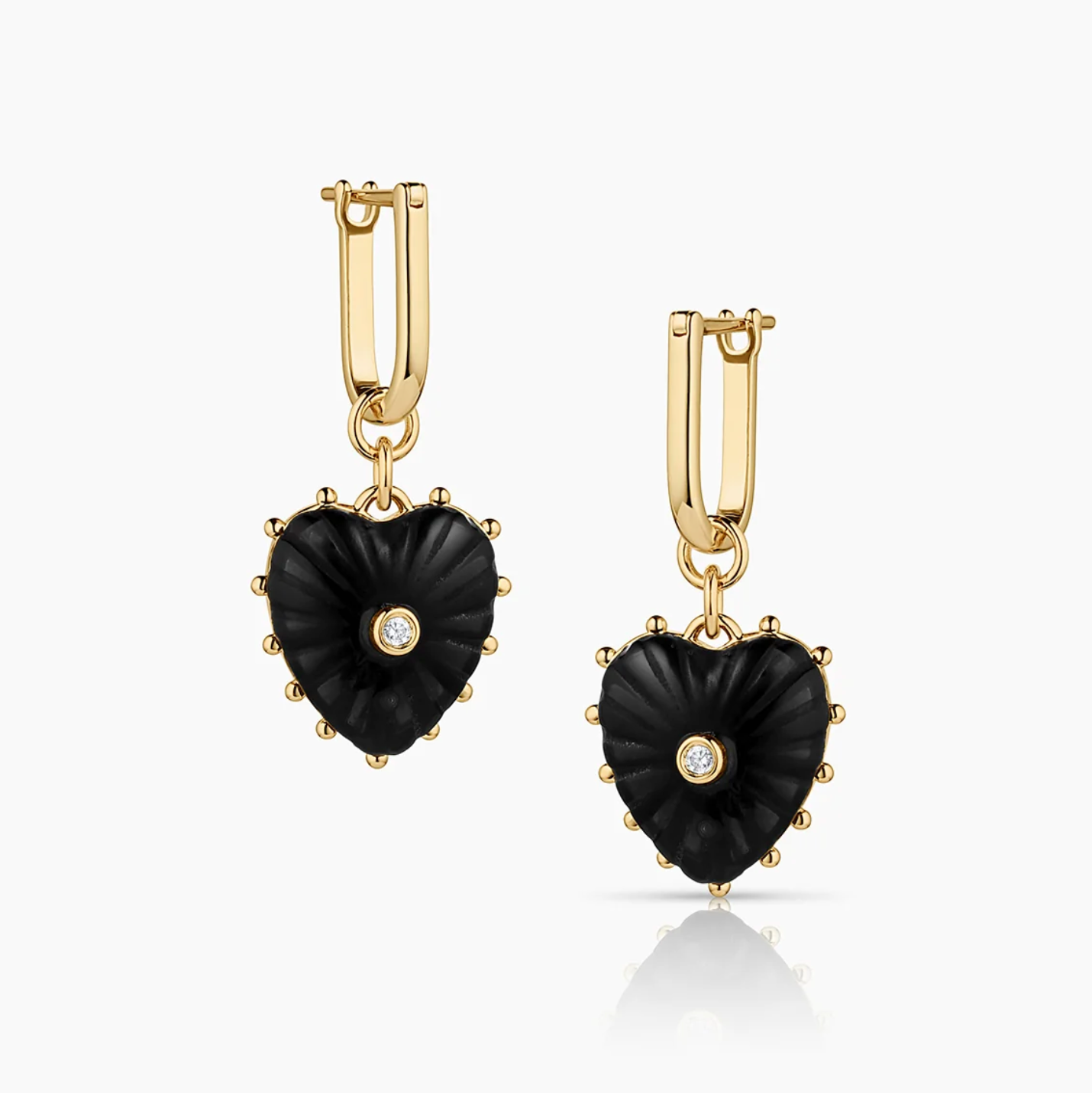 14k gold plated hoop earrings with removable hand-carved onyx heart charms and cubic zirconia center stones.