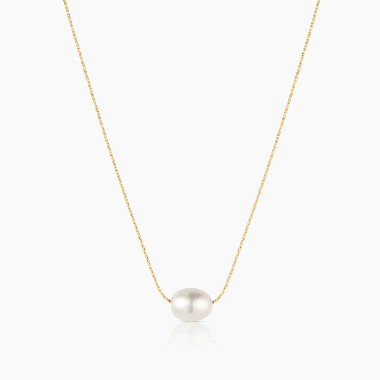 a gold chain with an large oval pearl over a white background