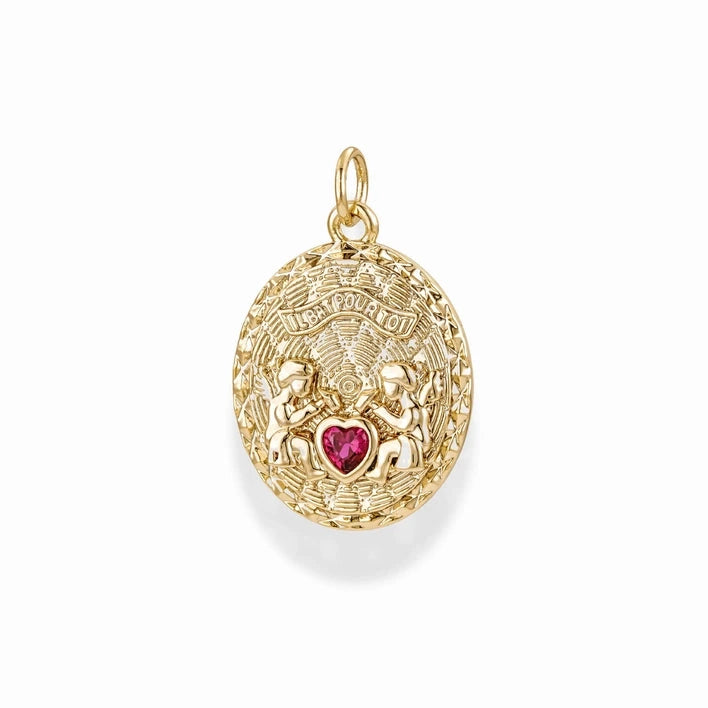 a gold oval shaped charm with two angels, text reading il bat pour toi, and a ruby cubic zirconia heart on a white background