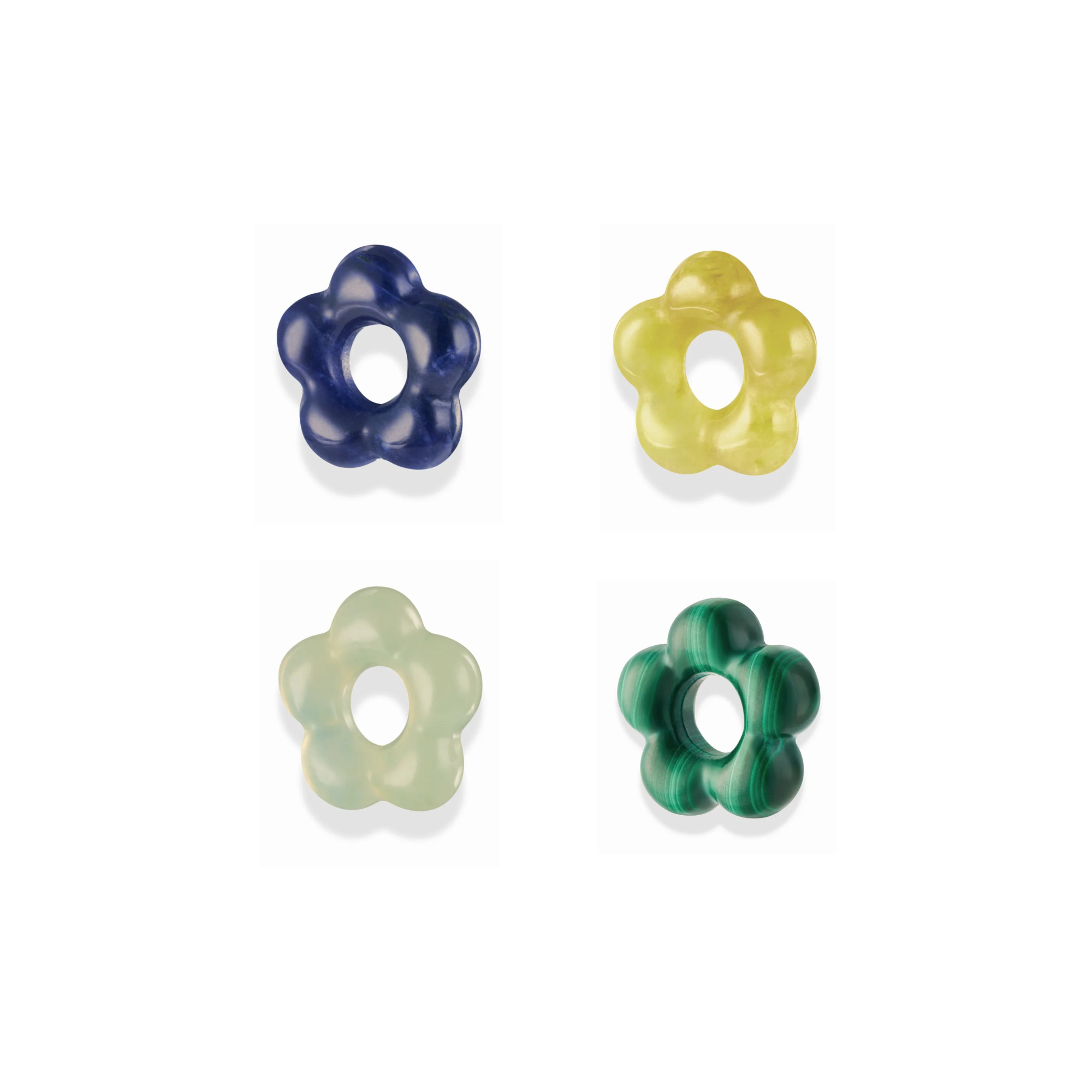 four multi-colored gemstone spacer beads, each in the shape of a flower, over a white background
