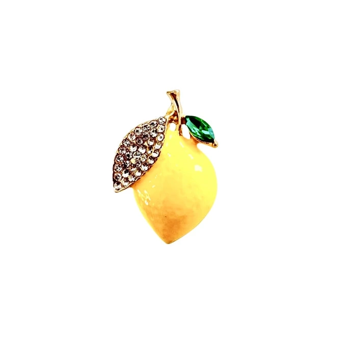 a yellow and green brooch in the shape of a lemon with a white background