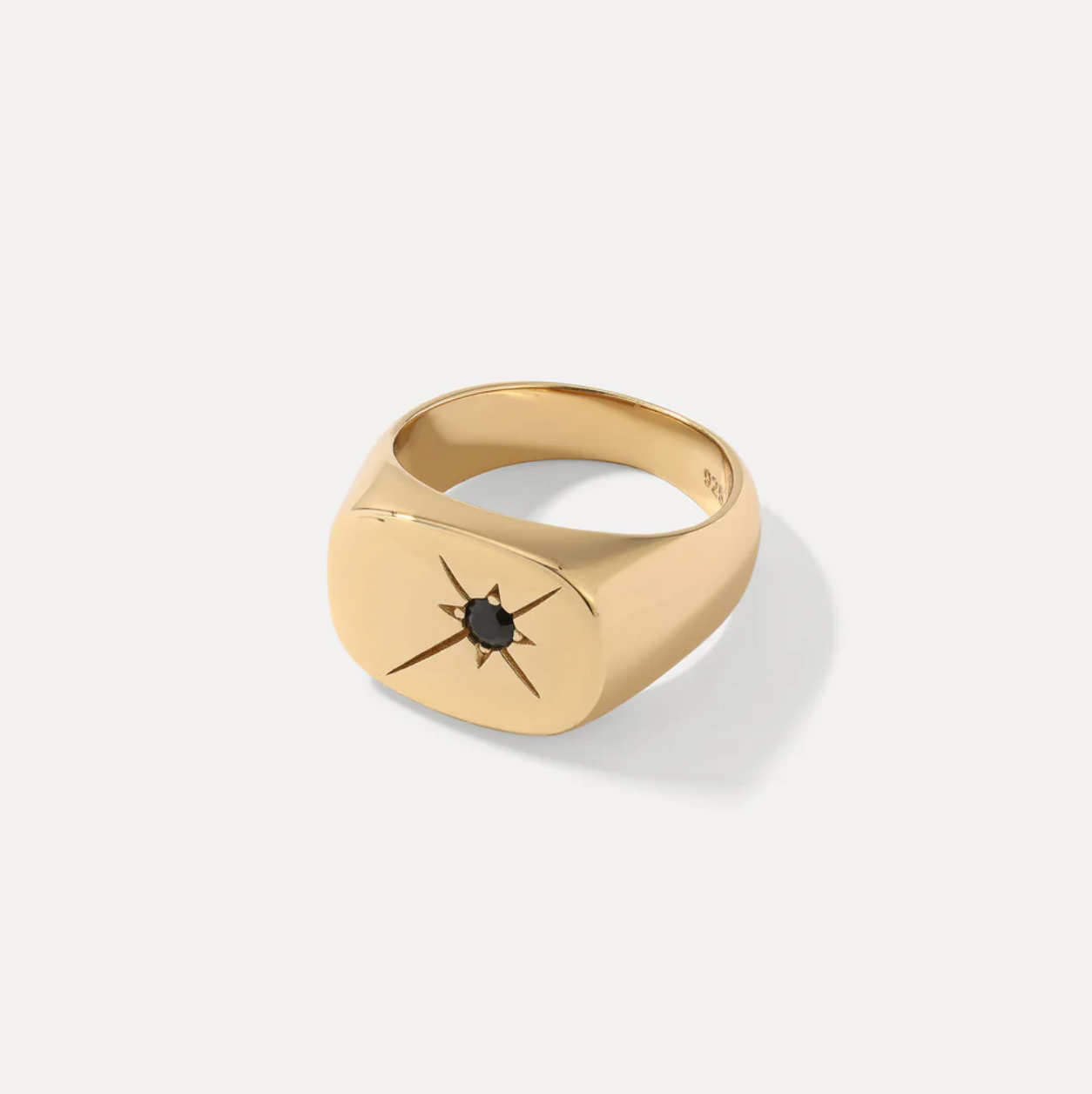 Gold ring with a black gemstone on a white background