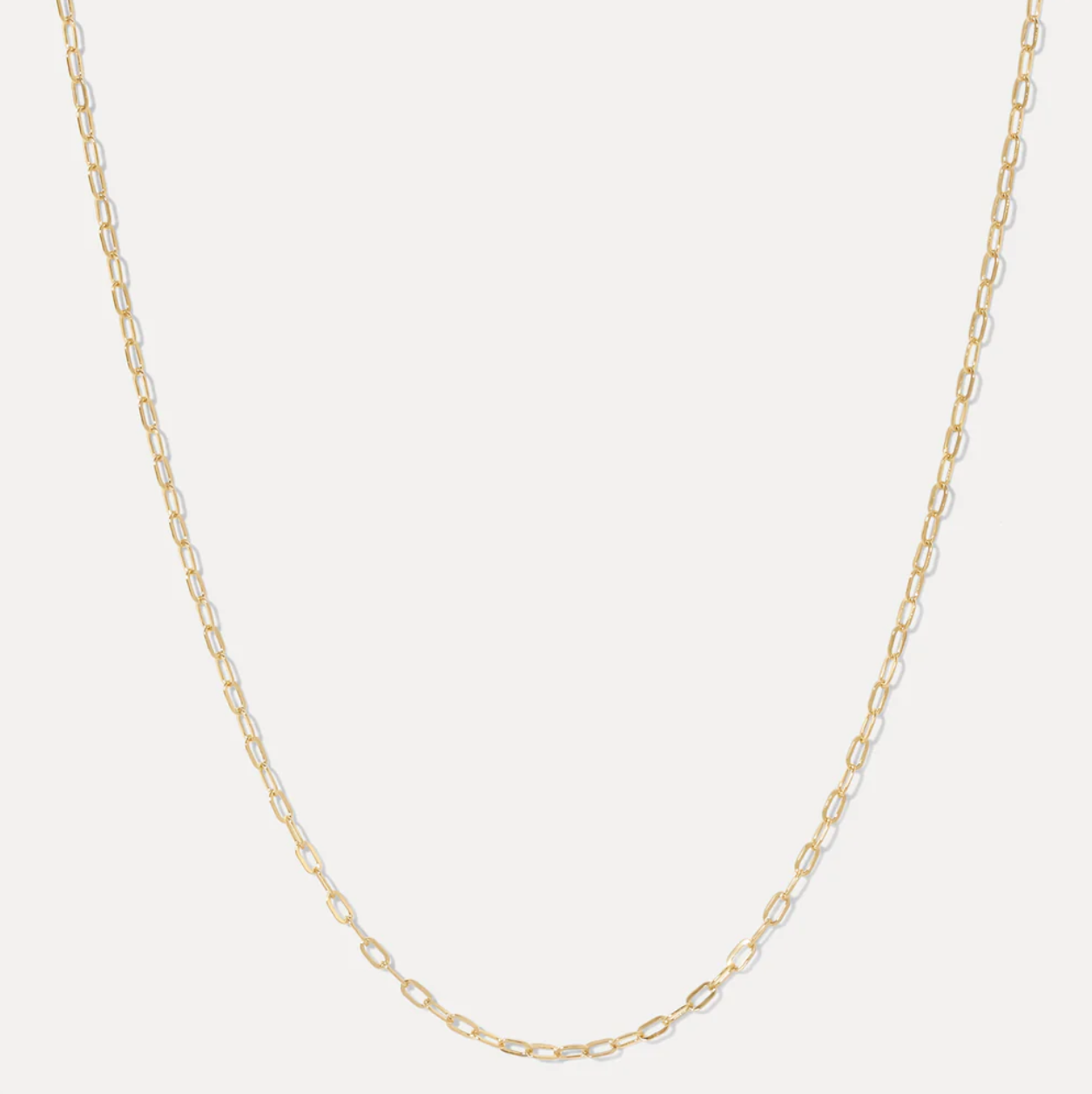 Gold chain necklace on a light gray background