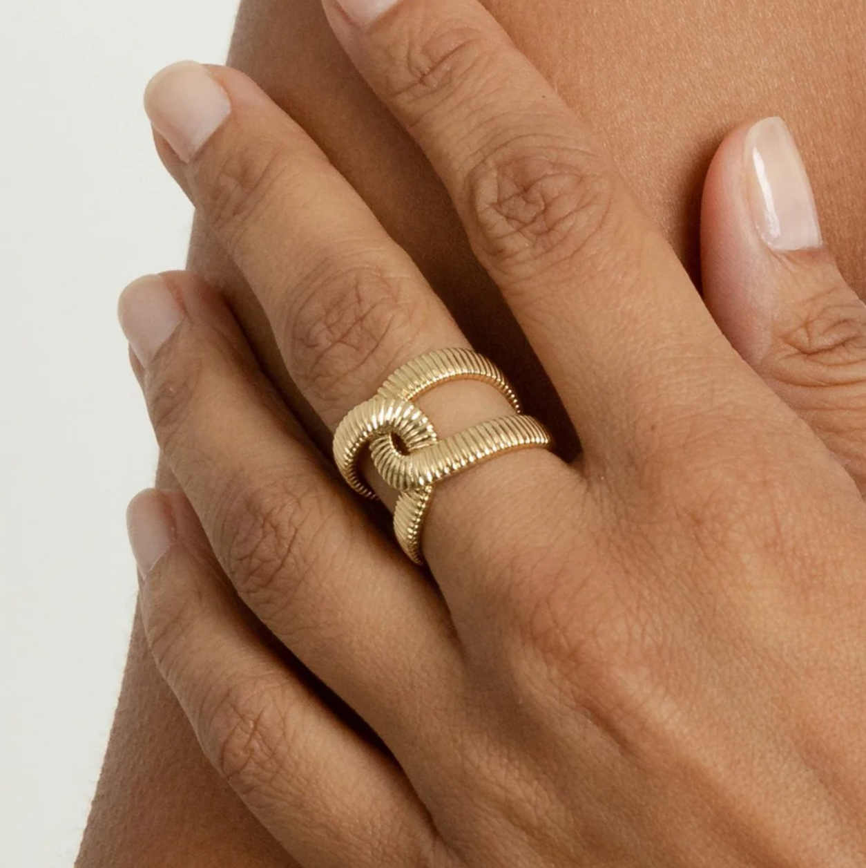 Adjustable gold ribbed ring on model hand
