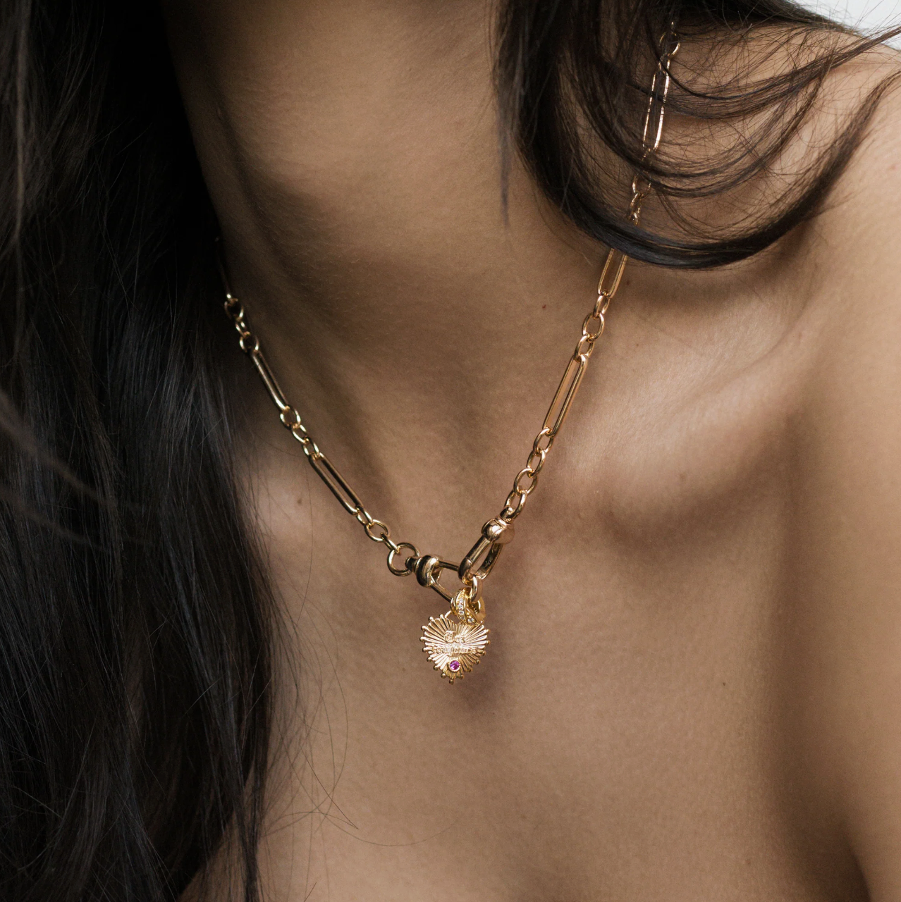Unique gold trombone chain and double clasp front closure on a model with a charm