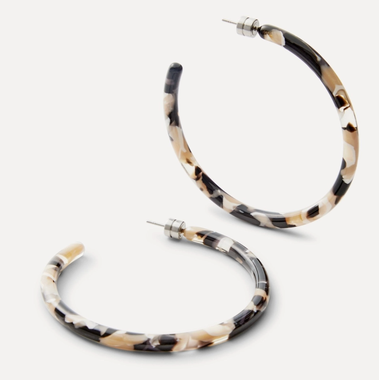 Pair of tortoiseshell hoop earrings on a white background