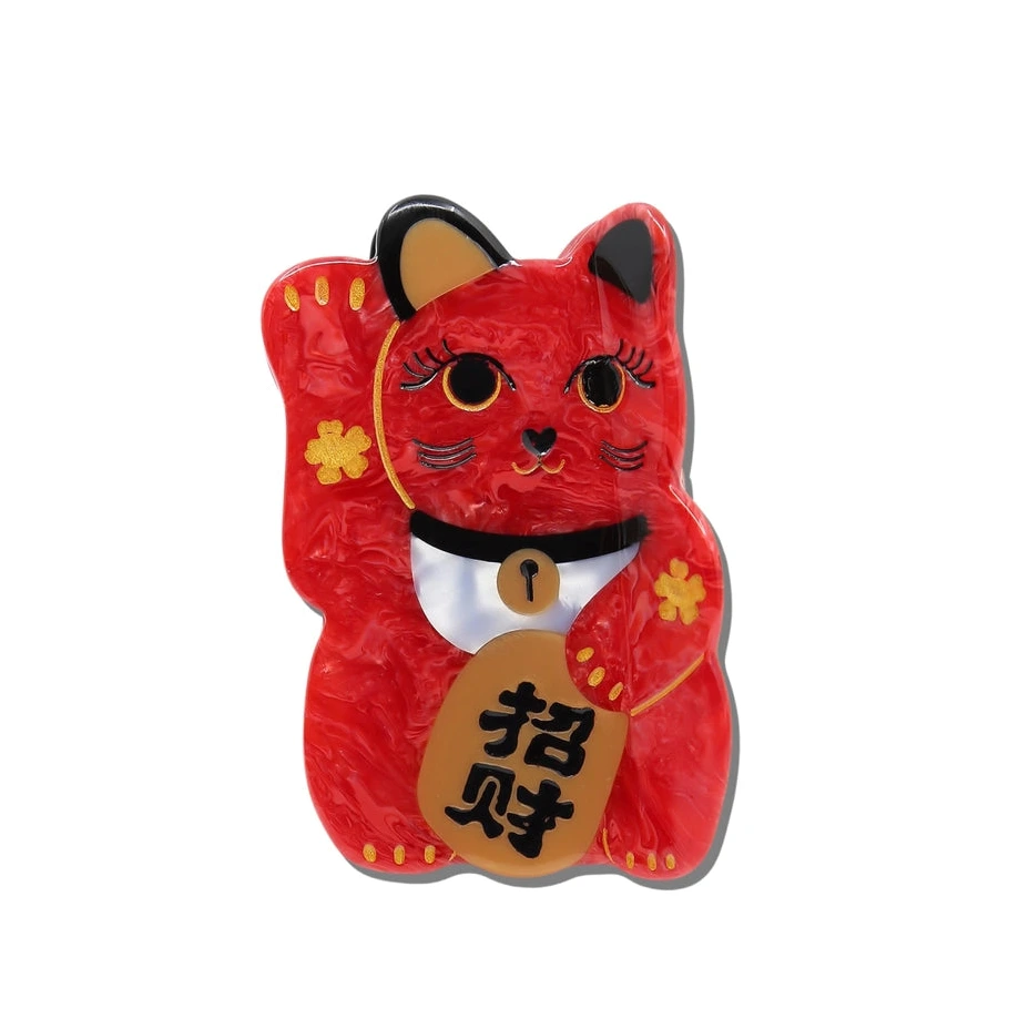 Red cat-shaped hair clip with a gold tag on a white background